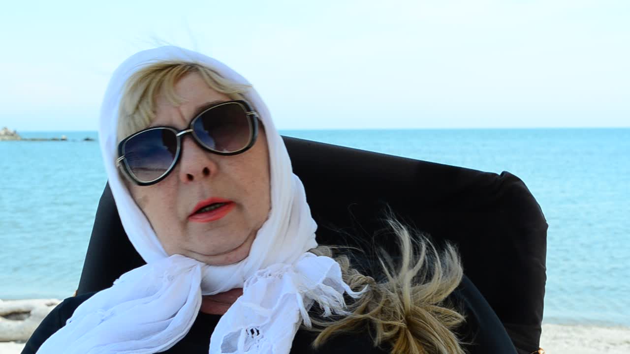 Havtur. Damen i en stol ved havet