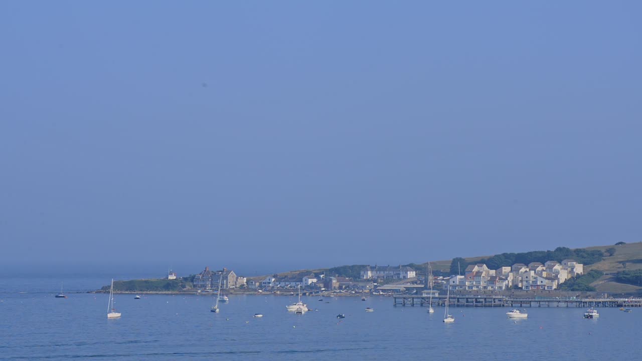 The Beautiful Town In Swanage, England With Blue Calm Ocean and Clear Blue Sky Above - Wide Shot