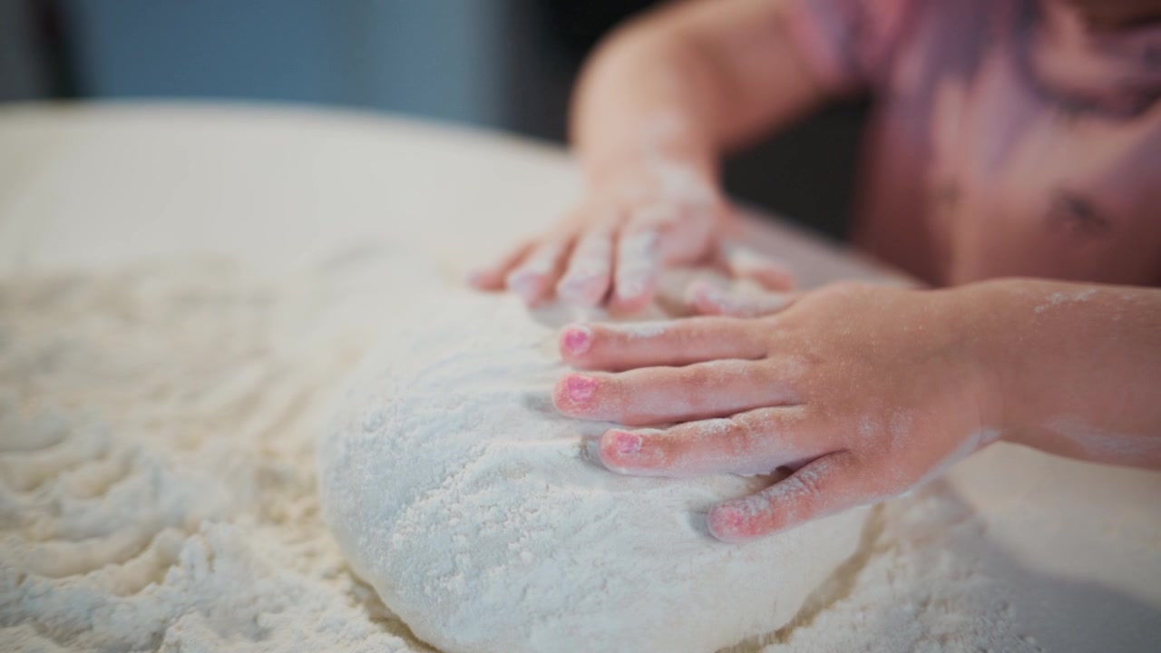 Close-up of hands kneading white dough on floured surface. Person focused, careful, and skilled in handling the dough. Ideal for cooking, baking, or food preparation content