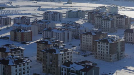 Drone-Rodeando-Bloques-De-Apartamentos-Cubiertos-De-Nieve-Por-La-Estación-De-Esquí-Sarikamis-En-Coches-Turquía