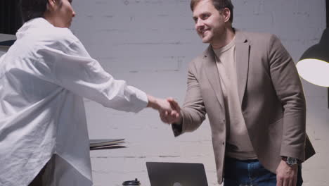 businessman and businesswoman finishing meeting with handshake