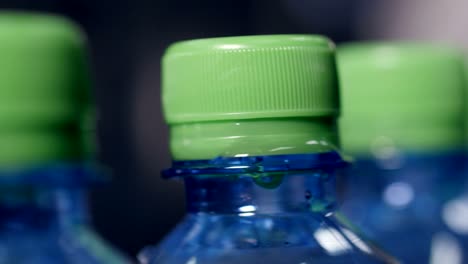 a closeup view of green caps on mineral water bottles.