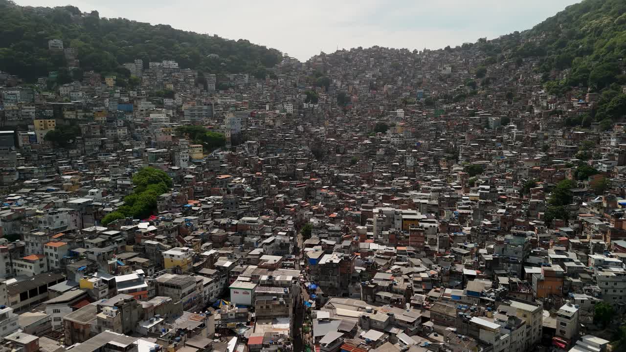 Aerial ascend flyover climbs over Rocinha favela on steep hills, Rio de Janeiro