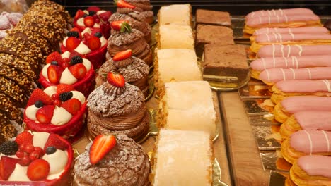 assorted pastries and cakes on display at a bakery