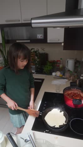 young girl cooking pancakes