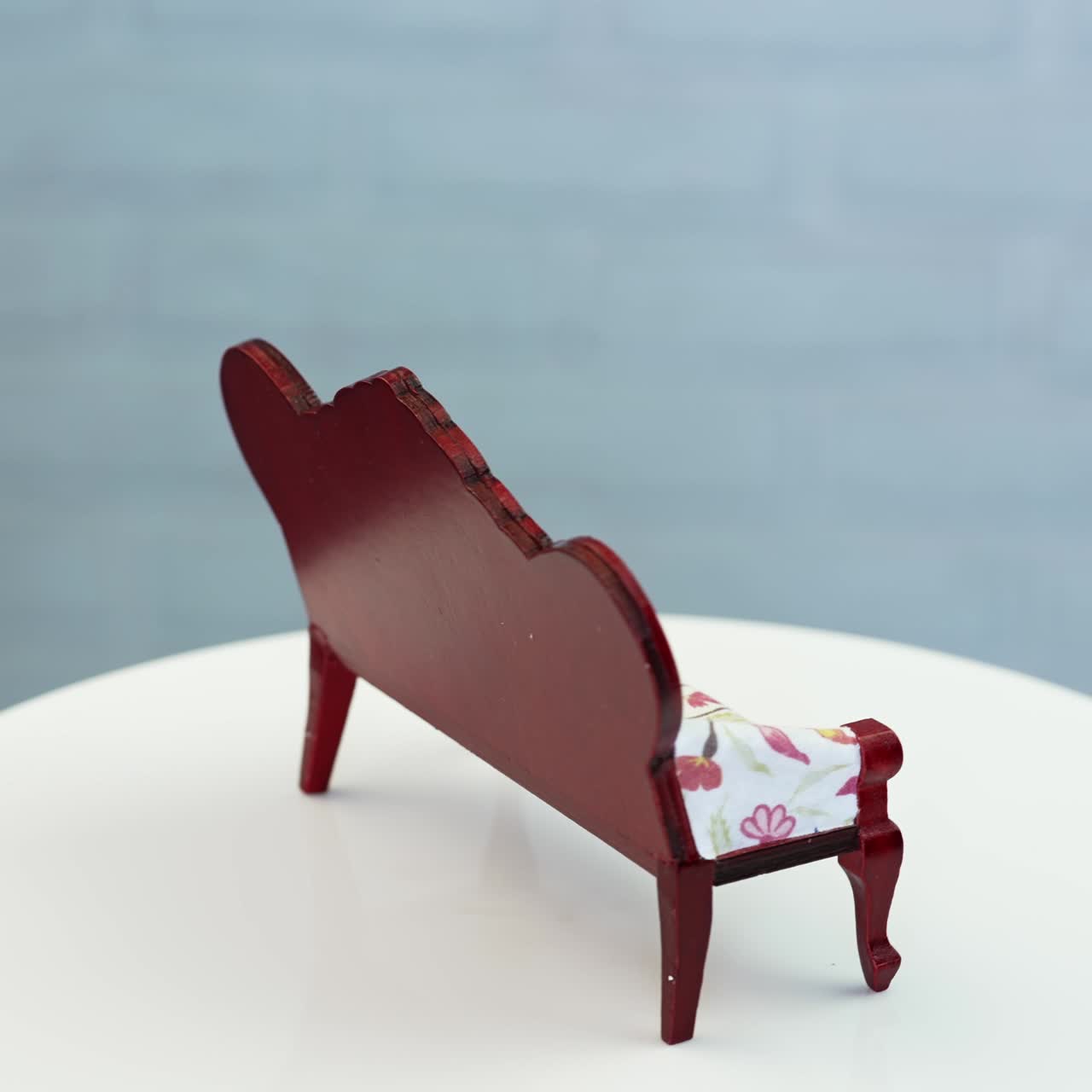 Amazing old-fashioned sofa for doll's house furnishing. Adorable piece of miniature furniture at the rotating table. Close up