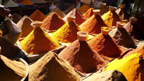 a colorful display of spices: vibrant mounds of various ground spices in a bustling market, showcasing an array of textures and shades that capture the essence of culinary diversity