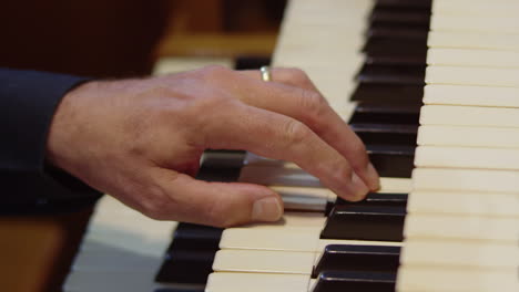 Cinematic-slow-motion-close-up-male-musician-hand-playing-piano-keys