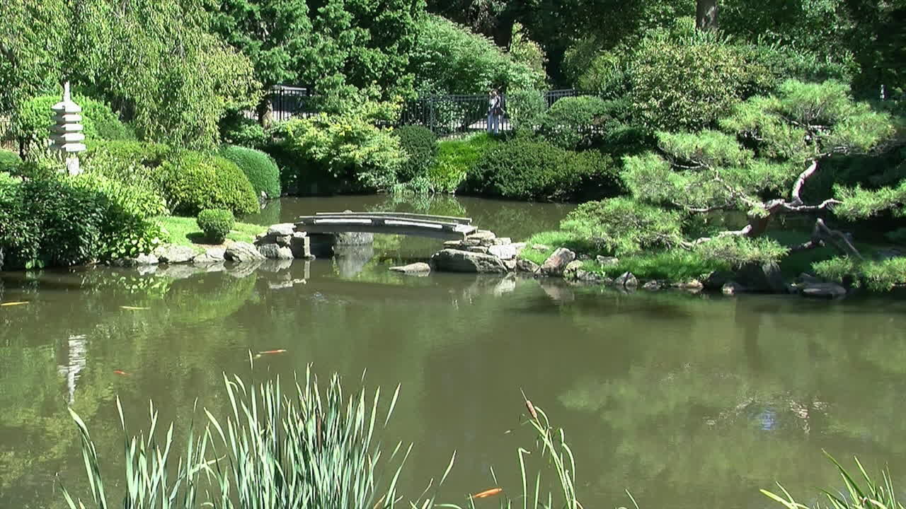 estanque con pasarela y pagoda en un jardín japonés