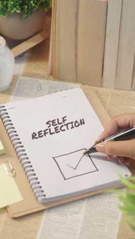 vertical video of ticking off self reflection work from checklist