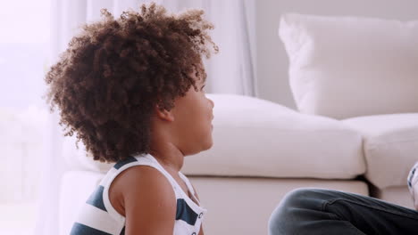 young black girl sitting next to her father playing ukulele