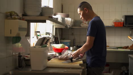 Close-up-front-angle-shot-of-a-chef-preserving-the-chopped-meat-into-a-polythene-cover