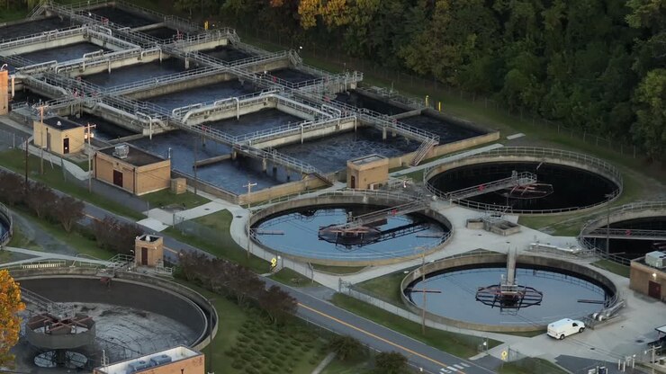 Aerial view of pools and pond of wastewater treatment plant in United States. Dusk scene in the evening. Water purification plant in USA. Wide shot