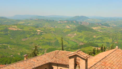 Aerial-drone-shot-over-beautiful-green-grasslands-over-hilly-terrain-in-northern-Italy-on-a-bright-sunny-day