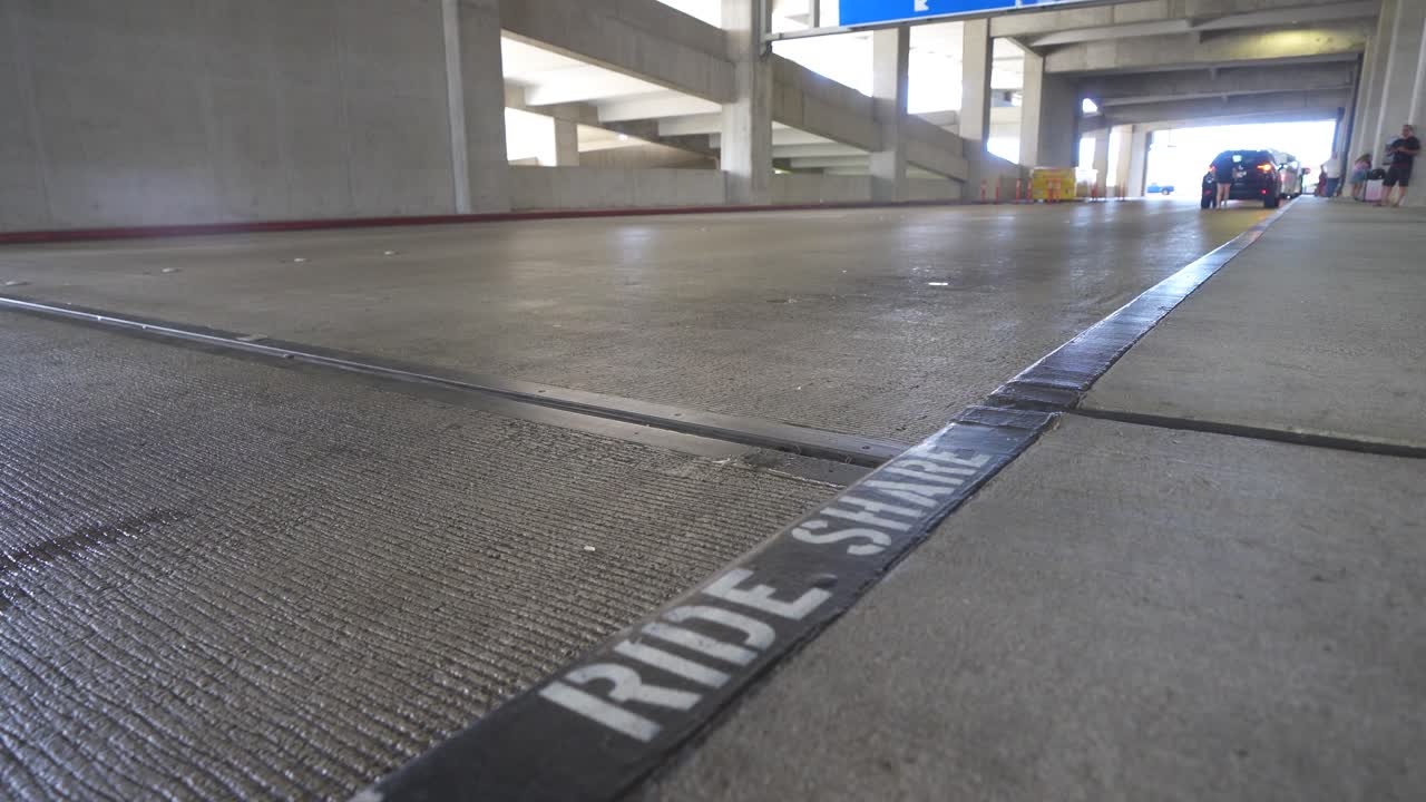 los coches circulan por el cartel de recogida de viajes compartidos en el aeropuerto de honolulu