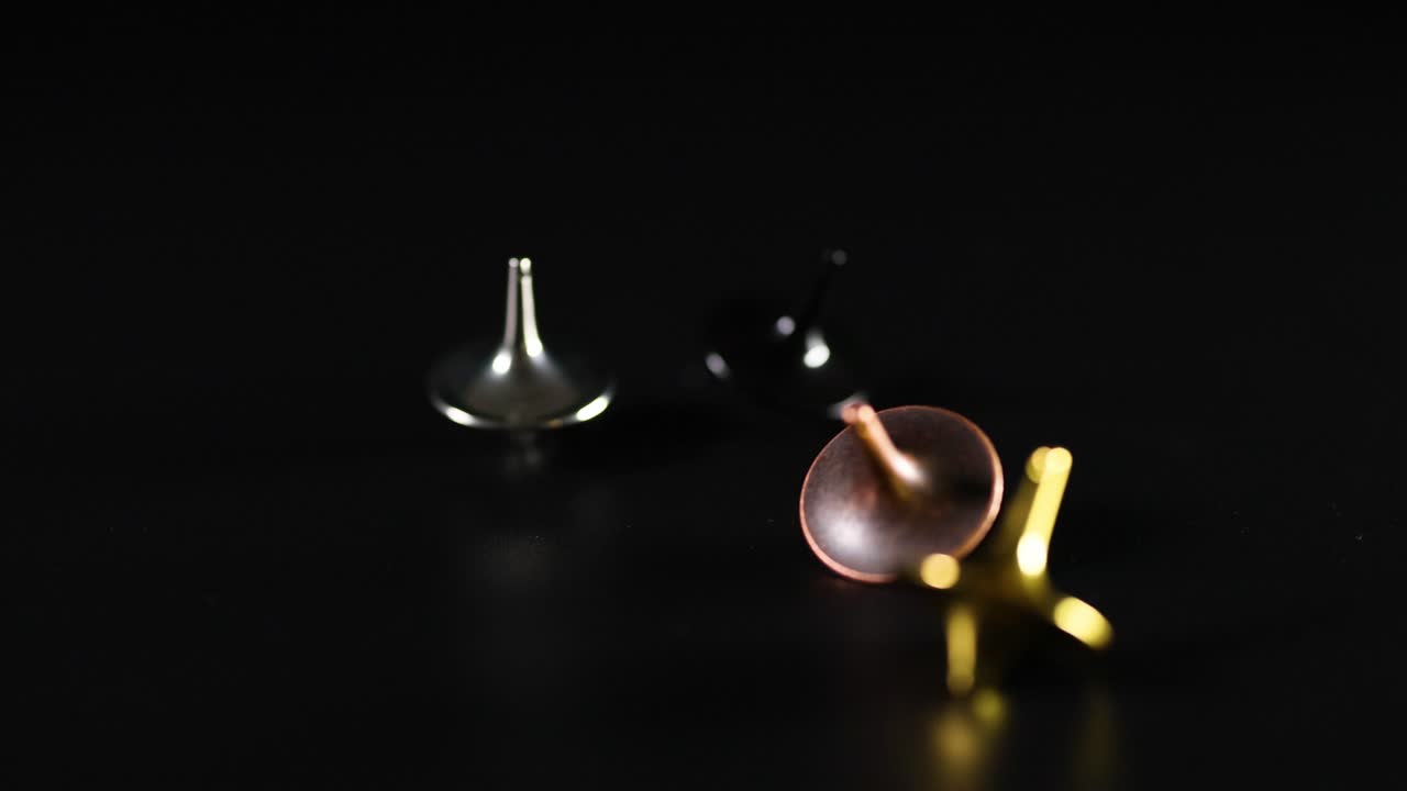 varias cimas girando en una superficie oscura