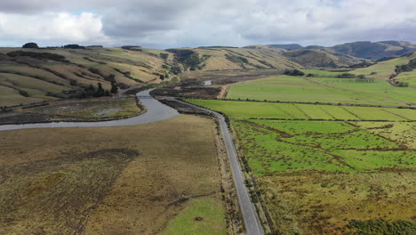 vista aérea de una carretera que serpentea a través de campos de patchwork en el paisaje rural pintoresco de nueva zelanda