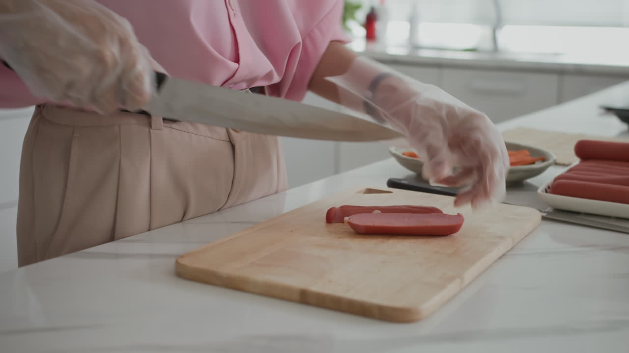 Unrecognizable Housewife Cutting Sausage for Dinner
