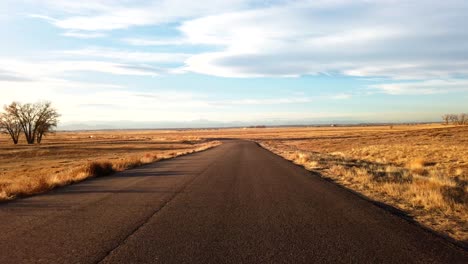 driving in the countryside of colorado during a sunny winter day