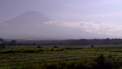 tractor tending to agricultural farmland at the bottom of silhouette mt