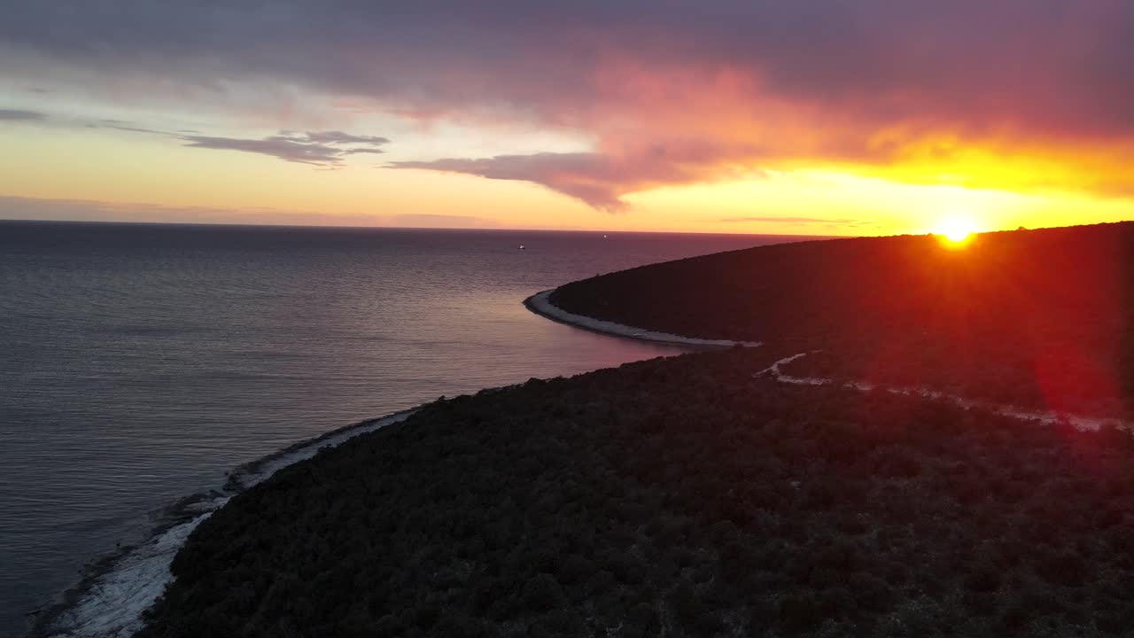 frente aéreo del bosque costero y el mar contra la puesta de sol de fuego dorado, uvala mrtvask, isla de cres, croacia