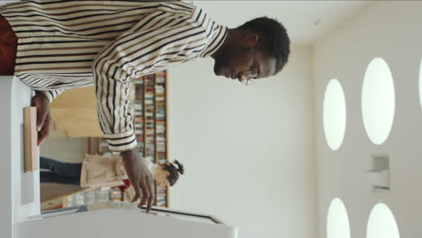 african man using interactive display in modern library
