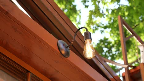 vintage light fixture with exposed bulb mounted on a wooden wall