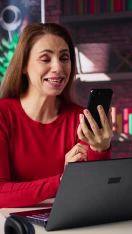 vertical video mature cheerful woman attending online class via video conference on her phone