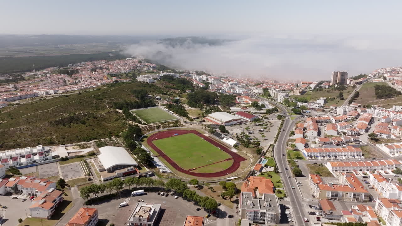 vista aérea de una ciudad costera en portugal con complejo deportivo y niebla