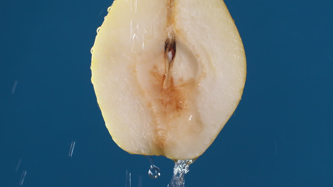 파란색 어두운 배경에 있는 노란색 반 배, 물 방울이 배 아래로 굴러 떨어지고 격리된 배경으로 흐르는 물 방울