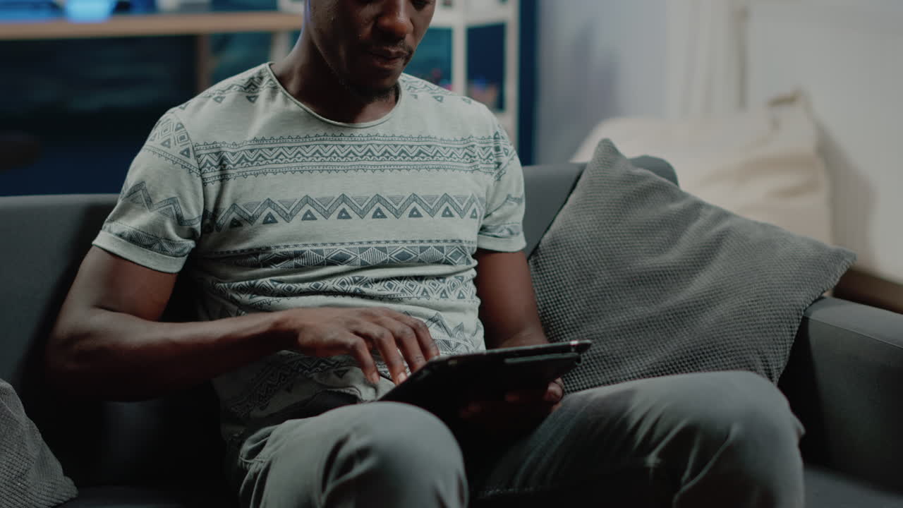 Close up of african american man typing on digital tablet