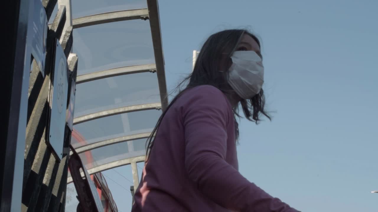 Woman wearing mask with coffee cup at train station medium shot