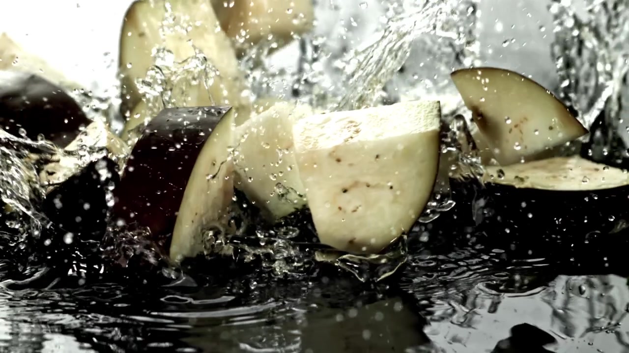 Chopped Eggplant Pieces Falling into Water with Splashes in Slow Motion