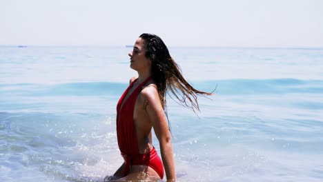 Beautiful-woman-tossing-her-hair-in-air-at-beach