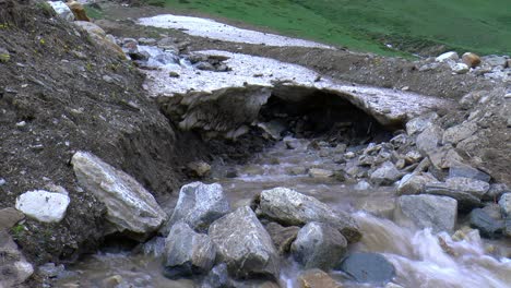 small waterfall flows under the snow