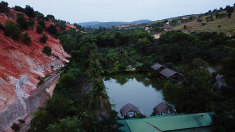 Orange-sand-dunes-and-tropical-Vietnam-village-destination-called-Fairy-Stream,-aerial-drone-shot