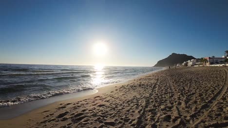 drone vuela despegando de la playa y vuela sobre las olas del mar