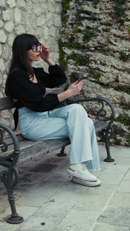woman on the bench picking up the smartphone to make some photos