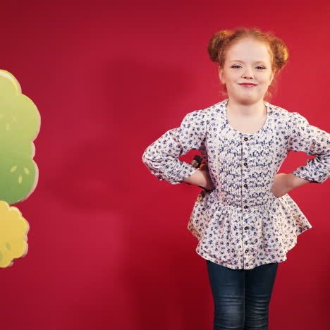 little cute little girl in the studio. cute redheaded child on red background square video