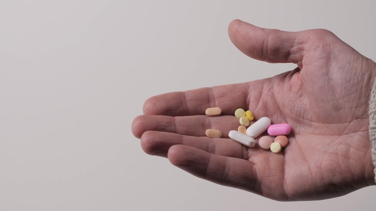 Different kinds pills in men's palm.