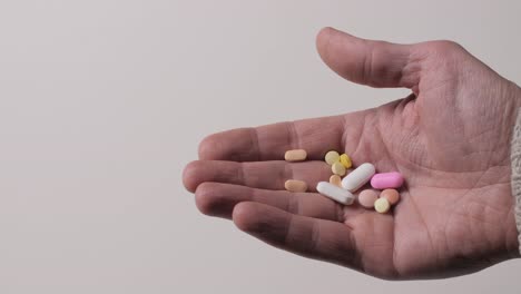 different kinds pills in men's palm.