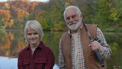grandfather and grandson fishing by a lake in autumn