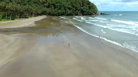 Aerial-top-view-of-couple-on-a-empty-beach,-São-Tomé-Island