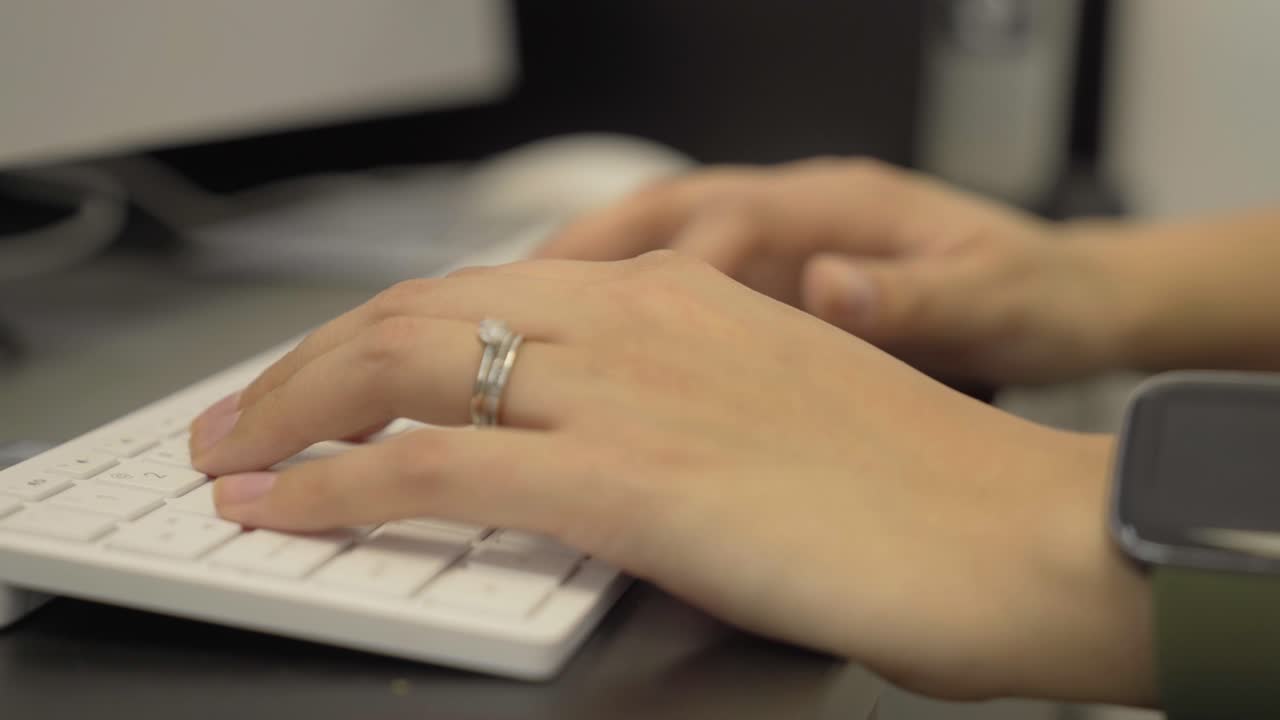 Woman typing on keyboard at work on an apple device