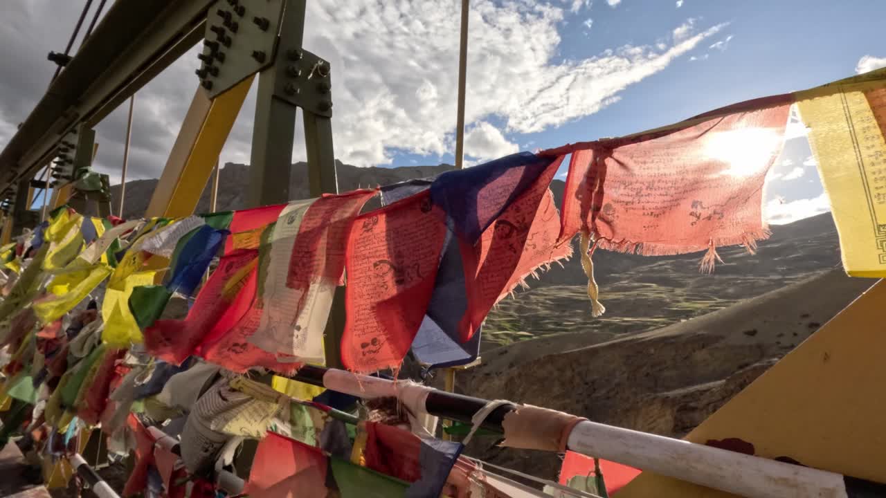 Colorful Buddhist prayer flags fluttering in wind, strung along Chicham Bridge