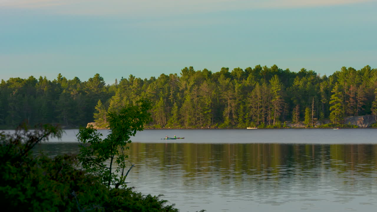 каякеры на вечерней прогулке по живописному озеру