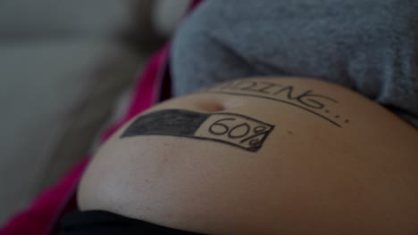 vientre embarazada con una barra de carga del 60% pintada, que simboliza las 24 semanas de embarazo