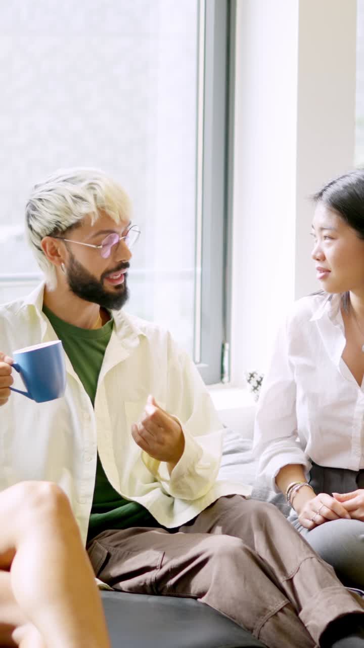 Coworkers chatting relaxed during coffee break sitting on comfortable chairs