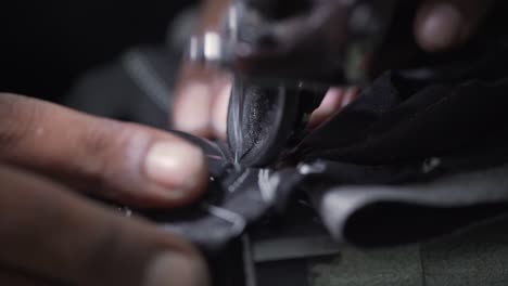 guantes de cuero cosidos en una máquina de coser por un trabajador de una fábrica explotadora