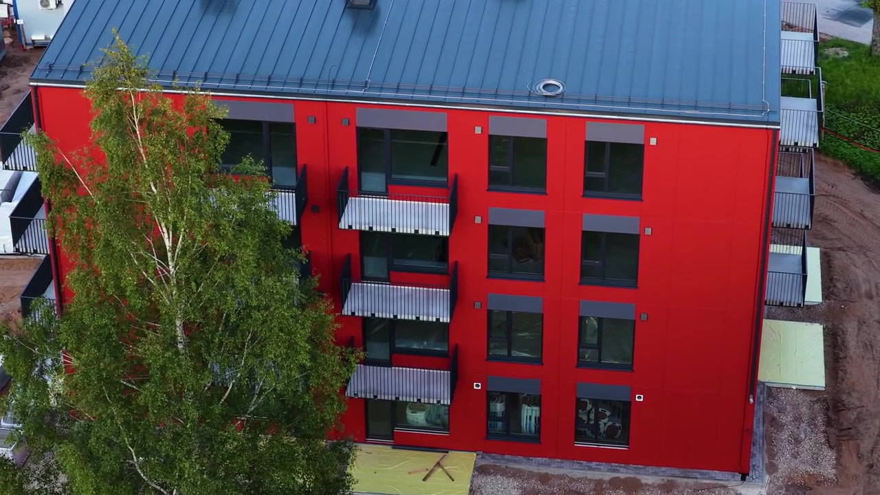 Edificio de apartamentos residencial rojo de nueva construcción con diseño de fachada moderno en vista aérea